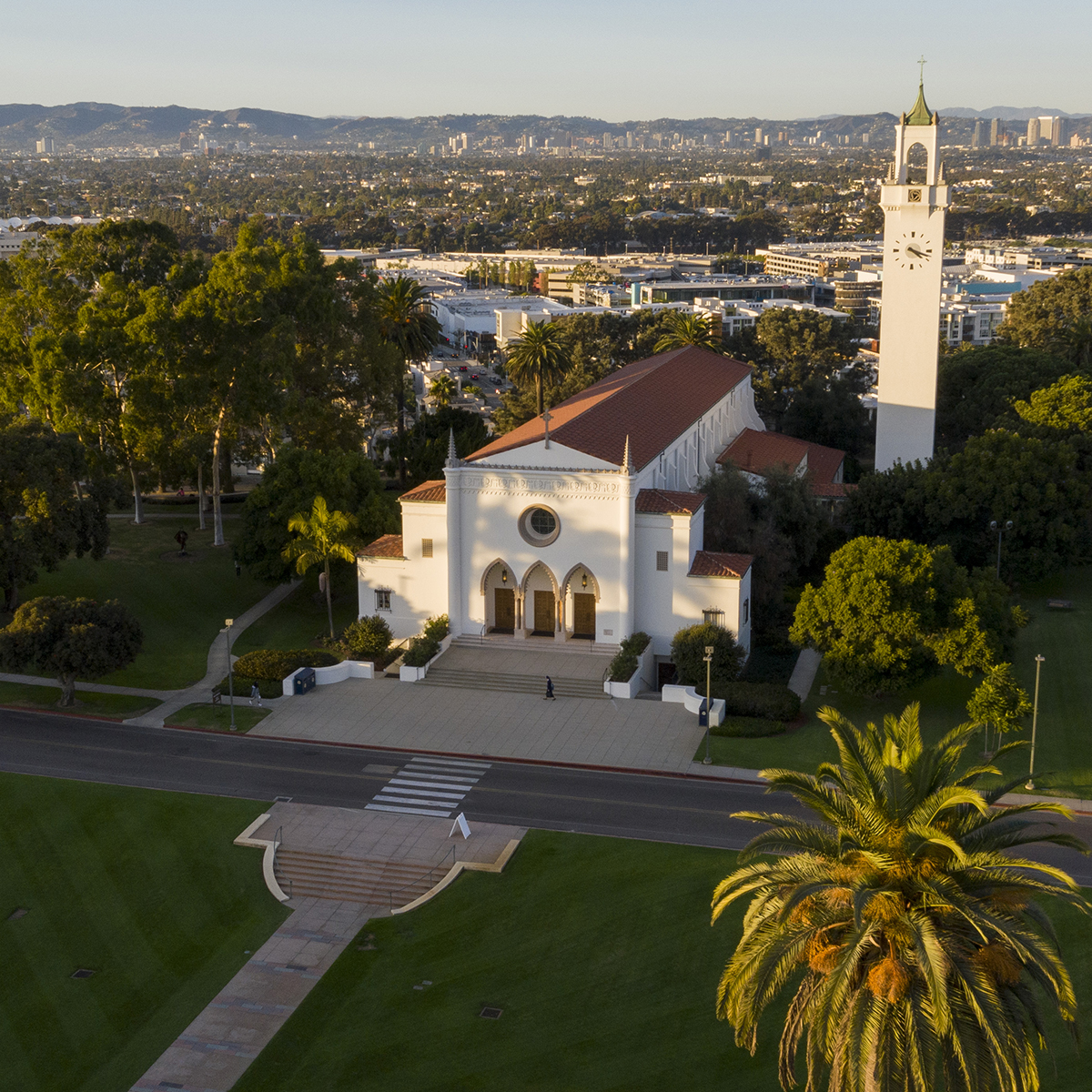 An aerial shot of Sacred Heart Chapel with Sunken Garden in the foreground and the city of Los Angeles in the background.
